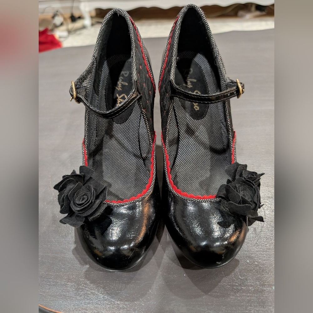 Ruby Shoo Ashley Mary Jane heels featuring a floral accent and red trim. 